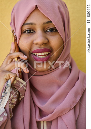 Digital Connection: Close-up Portrait of a Middle Eastern Teenage Muslim Girl Using Smartphone 114880421