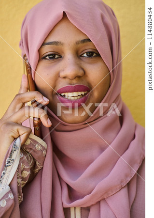 Digital Connection: Close-up Portrait of a Middle Eastern Teenage Muslim Girl Using Smartphone 114880434