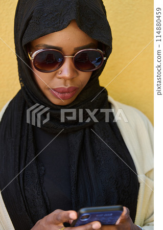 Digital Connection: Close-up Portrait of a Middle Eastern Teenage Muslim Girl Using Smartphone 114880459