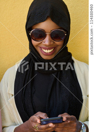 Digital Connection: Close-up Portrait of a Middle Eastern Teenage Muslim Girl Using Smartphone Digital Connection: Close-up Portrait of a Middle Eastern Teenage Muslim Girl Using Smartphone 114880460