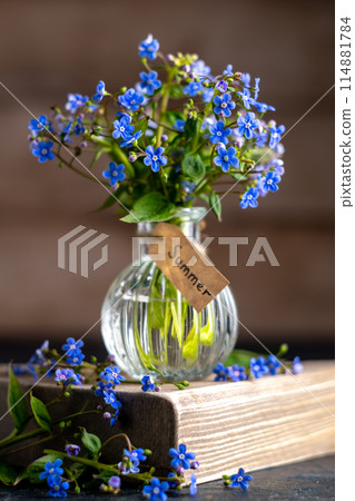 bouquet of blue forget-me-nots in a glass vase. congratulation, beautiful card for birthday, mother's day and wedding, symbol of love and fidelity, text summer bouquet of blue forget-me-nots in a glass vase. congratulation, beautiful card for birthday, mother's day and wedding, symbol of love and fidelity, text summer 114881784