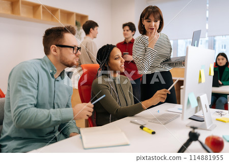 Modern corporate office open space with busy male and female staff employees using laptop computers sitting at work in big modern corporate office. Startup team working together at creative open space 114881955