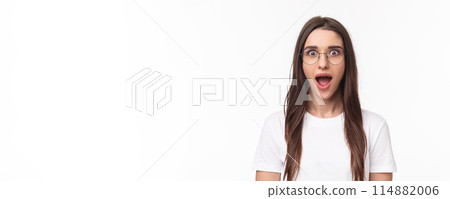 Close-up portrait of enthusiastic, intrigued young brunette woman listening with dropped jaw to amazing news, open mouth fascinated, standing white background, heart great idea, wear glasses 114882006