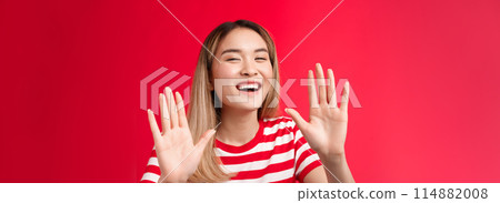 Fine I give up. Emotive happy outgoing young cute asian girl laughing joyfully say ok raise hands surrender joking around, agree friend terms having fun fool around, stand red background 114882008