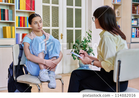 Counselor working with teenage girl high school student in office educational building Counselor working with teenage girl high school student in office educational building 114882016