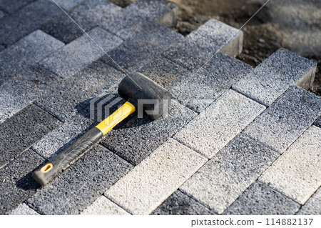 Garden brick pathway paving by professional paver worker. Repairing sidewalk. Garden brick pathway paving by professional paver worker. Repairing sidewalk. 114882137