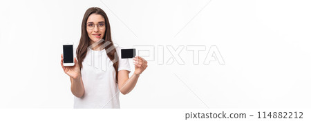 Portrait of excited and tempting young woman likes shopping, cant wait to use her new credit card in online store, showing mobile phone screen, brag with her bank account, bite lip thrilled Portrait of excited and tempting young woman likes shopping, cant wait to use her new credit card in online store, showing mobile phone screen, brag with her bank account, bite lip thrilled 114882212