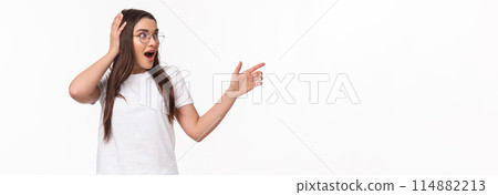 Waist-up portrait of surprised, astonished young brunette woman, 20s years, pointing and looking right, touch head cant believe she sees something so awesome, startled standing white background Waist-up portrait of surprised, astonished young brunette woman, 20s years, pointing and looking right, touch head cant believe she sees something so awesome, startled standing white background 114882213
