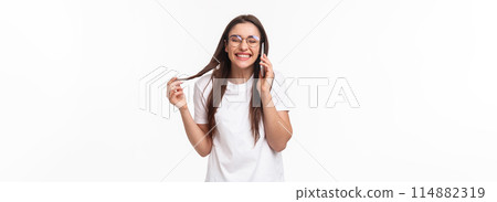 Communication, technology and lifestyle concept. Portrait of talkative funny and carefree, happy young caucasian woman talking on phone with friend, laughing over jokes, stand with mobile phone 114882319