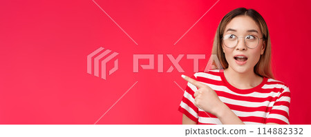 Amused wondered cute asian blond modern girl surprised, looking pointing left intrerested open mouth fascinated amazed, checking out interesting event, attend curious exhibition, red background Amused wondered cute asian blond modern girl surprised, looking pointing left intrerested open mouth fascinated amazed, checking out interesting event, attend curious exhibition, red background 114882332