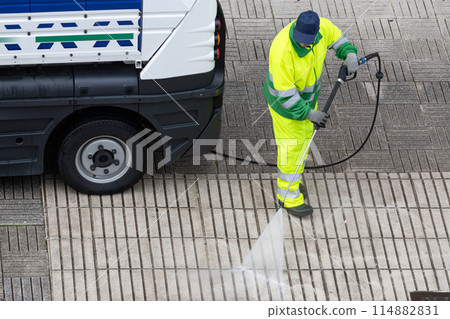Worker cleaning a street sidewalk with high pressure water jet machine Worker cleaning a street sidewalk with high pressure water jet machine 114882831