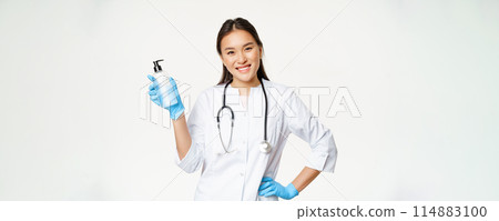 Smiling asian physician holding hand sanitizer in rubber gloves, showing bottle with antiseptic for coronavirus prevention, white background Smiling asian physician holding hand sanitizer in rubber gloves, showing bottle with antiseptic for coronavirus prevention, white background 114883100