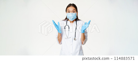 Portrait of happy asian female doctor clap hands, looking enthusiastic at surprising news, wearing medical mask and rubber gloves, white background Portrait of happy asian female doctor clap hands, looking enthusiastic at surprising news, wearing medical mask and rubber gloves, white background 114883571