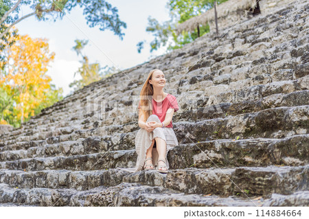 Woman tourist at Coba, Mexico. Ancient mayan city in Mexico. Coba is an archaeological area and a famous landmark of Yucatan Peninsula. Cloudy sky over a pyramid in Mexico Woman tourist at Coba, Mexico. Ancient mayan city in Mexico. Coba is an archaeological area and a famous landmark of Yucatan Peninsula. Cloudy sky over a pyramid in Mexico 114884664