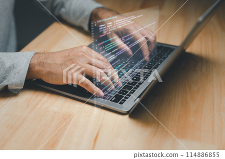 A man is typing on a laptop with a keyboard that is projected on the screen 114886855