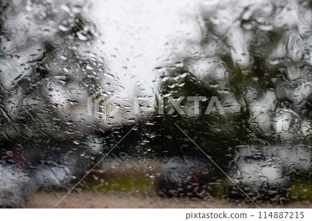 A blurry image of a car windshield with raindrops on it A blurry image of a car windshield with raindrops on it 114887215