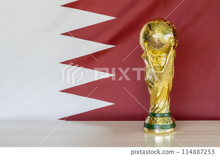 A gold soccer ball sits on a table next to a red and white flag A gold soccer ball sits on a table next to a red and white flag 114887253