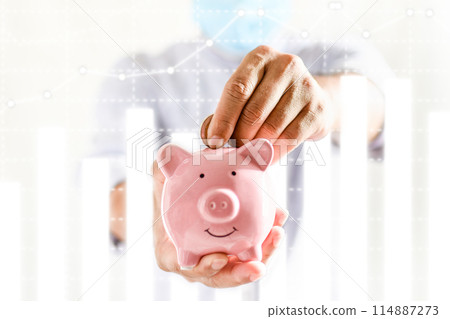 A person is holding a pink piggy bank A person is holding a pink piggy bank 114887273