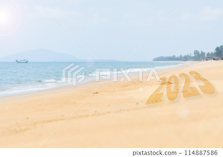 A beach with a boat in the water and the number 23 written in sand A beach with a boat in the water and the number 23 written in sand 114887586