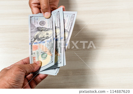 A person is holding three $100 bills A person is holding three $100 bills 114887620