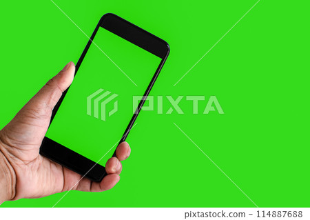 A person is holding a phone with a green screen 114887688