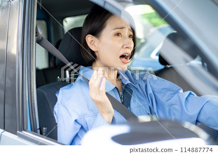 Surprised female driver while driving 114887774