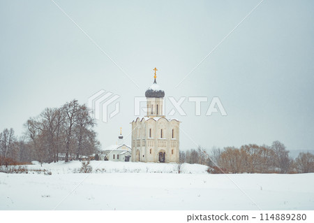 a church in winter in the middle of a snow-covered field 114889280