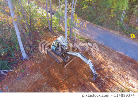 Tractors uproot trees as part of construction process Tractors uproot trees as part of construction process 114889374