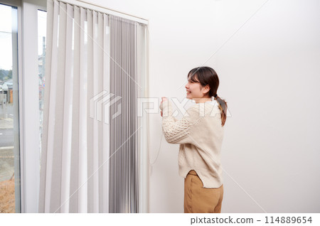 Woman opening curtains, house, residential 114889654
