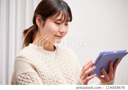 A woman who operates a tablet 114889676