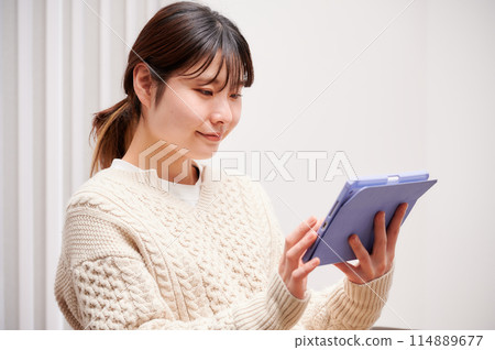 A woman who operates a tablet A woman who operates a tablet 114889677