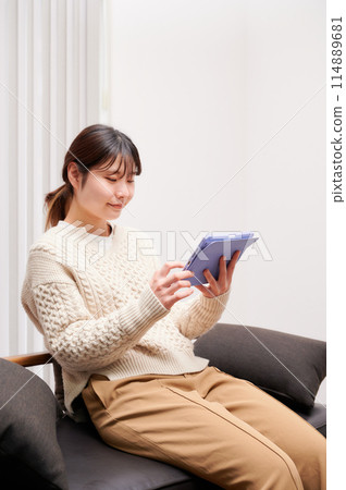 A woman who operates a tablet A woman who operates a tablet 114889681