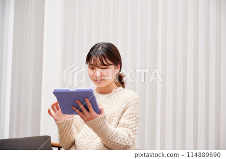 A woman who operates a tablet A woman who operates a tablet 114889690