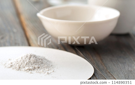 Small ceramic mortar, bowl and pestle with white powder on wooden background Small ceramic mortar, bowl and pestle with white powder on wooden background 114890351