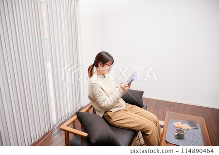 A woman who operates a tablet 114890464