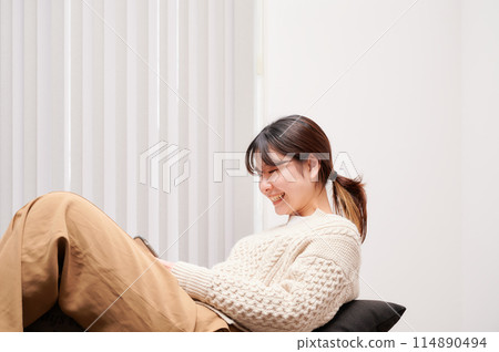 一位女士在家中操作智慧型手機 一位女士在家中操作智慧型手機 114890494