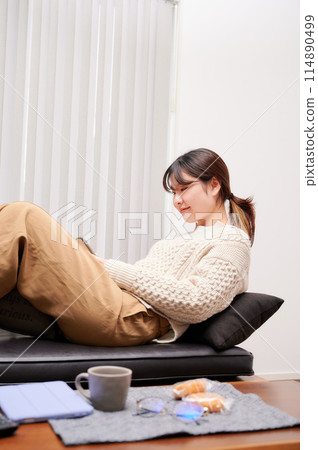 A woman operating a smartphone at home A woman operating a smartphone at home 114890499