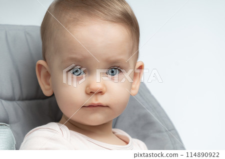 Close-up of a toddler baby gazing at the camera with calm face Close-up of a toddler baby gazing at the camera with calm face 114890922