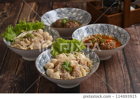 Close up view tasty rice noodles soup with pork and meat ball on wooden table. Asian food Close up view tasty rice noodles soup with pork and meat ball on wooden table. Asian food 114893915