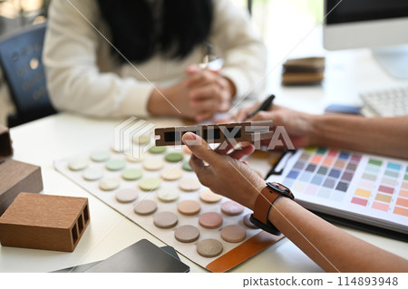 Interior designers working with furniture material samples at co working space in office 114893948