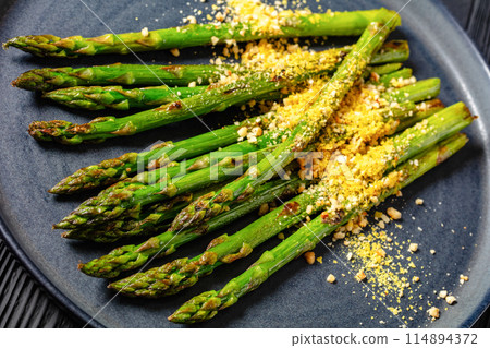roasted asparagus with nut yeast crumble on plate 114894372