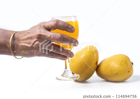 Refreshing mango juice in hand of Indian woman with ripe mangoes on white background Refreshing mango juice in hand of Indian woman with ripe mangoes on white background 114894736