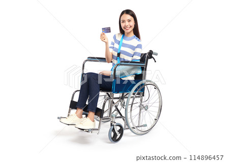 Beautiful young asian women with happy smiling and show credit card in a wheelchair on white background, healthcare concept, accident, insurance, life insurance, wellness, hospital. 114896457