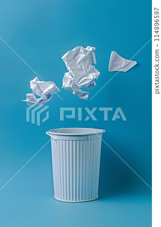 A paper trash can floating in the air with crumpled white papers against a light blue background in a minimal concept studio lighting style 114896597