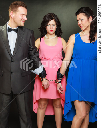 Wife and husband in handcuffs woman standing behind Wife and husband in handcuffs woman standing behind 114896918