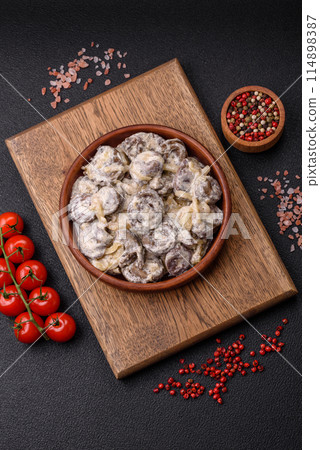 Boiled chicken hearts cut into slices with onions and cream sauce 114898387