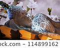 Nirvana white marble reclining Buddha, beautiful flower background. 114899162