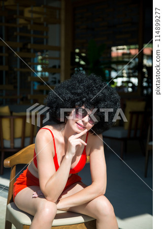 A saleswoman of a street store sunbathes on a hot summer day near the entrance A saleswoman of a street store sunbathes on a hot summer day near the entrance 114899277
