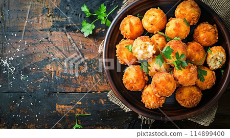 Deep fried arancini balls on rustic background - traditional Italian cuisine. Stuffed rice balls. 114899400