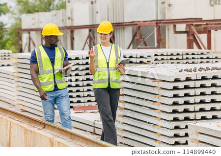 Engineer smart women working contact with African black worker in Precast concrete casting manufacturing company site inspector 114899440